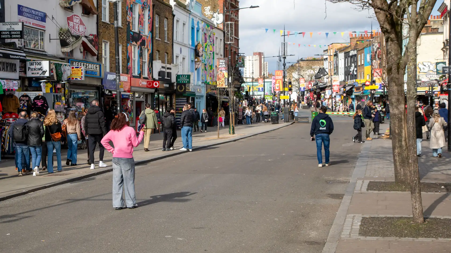 A visitor speaking with Denny, Camden Town's own voice guide, on Camden High Street